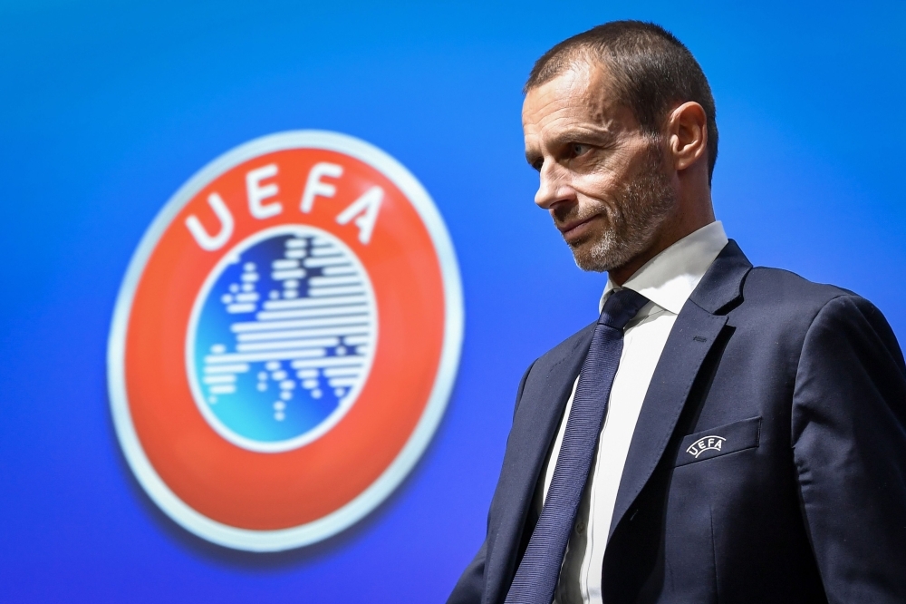 UEFA president Aleksander Ceferin walks past a sign with the UEFA logo after attending a press conference following a meeting of the executive committee at the UEFA headquarters, in Nyon, Switzerland on Wednesday. — AFP