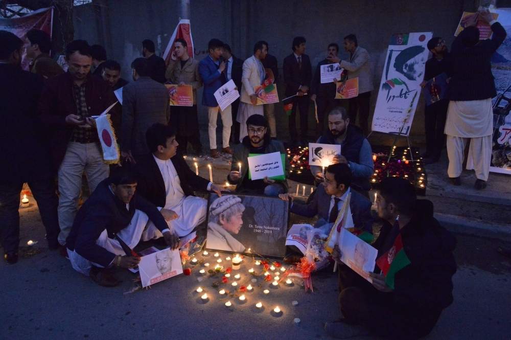 Afghans hold a candlelight vigil for slain Japanese doctor Tetsu Nakamura, who was killed in Jalalabad on Wednesday during a gunmen attack, in Kabul on Thursday. — AFP