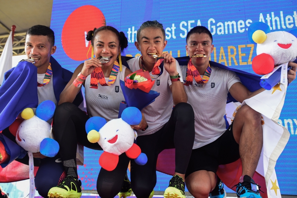 (L-R) Sherwin Managil, Glorien Merisco, Sandi Abahan and Mervin Guarte of the Philippines show off their silver and gold medals after their win at the SEA Games (SouthEast Asian Games) men’s and women’s 5k x 20 obstacle course held at the Filinvest Alabang, south of Manila on Friday. — AFP 