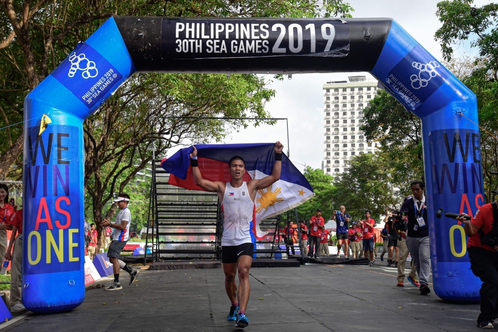 (L-R) Sherwin Managil, Glorien Merisco, Sandi Abahan and Mervin Guarte of the Philippines show off their silver and gold medals after their win at the SEA Games (SouthEast Asian Games) men’s and women’s 5k x 20 obstacle course held at the Filinvest Alabang, south of Manila on Friday. — AFP 