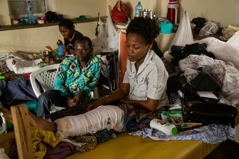 Kavugho Mbafumoja, right, 36, a survivor of an attack by an Armed Forces of the Democratic Republic of the Congo (FARDC) soldier, a few minutes after an attack that is attributed to the armed group of the Allied Democratic Forces (ADF), sits on a hospital bed the Beni General Hospital, in Beni, in this Dec. 3, 2019 file photo. — AFP