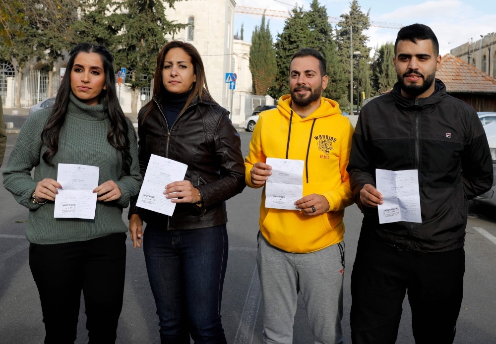 Palestinian journalists Dana Abou Shamsiyeh, left, Christine Renaoui second left, Ali Yassin, second right, and Amir Abed Rabbo, right, who were briefly detained by the Israeli authorities, is pictured upon their release in Jerusalem on Friday. — AFP