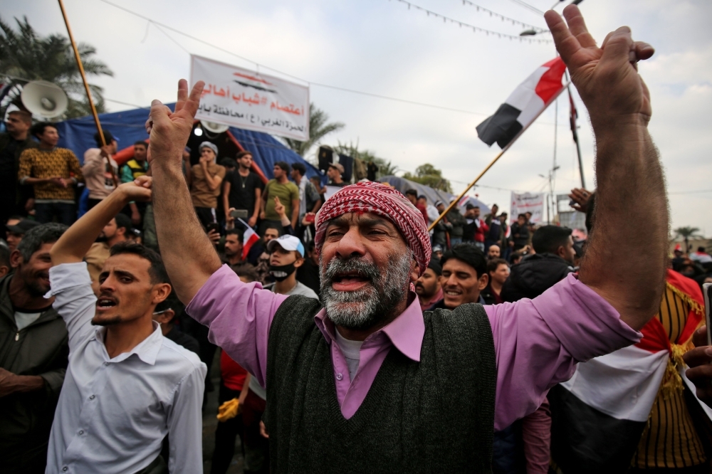 Iraqi demonstrators shout slogans as thee take part in an anti-government demonstration in the capital Baghdad's Tahrir Square on Friday. — AFP