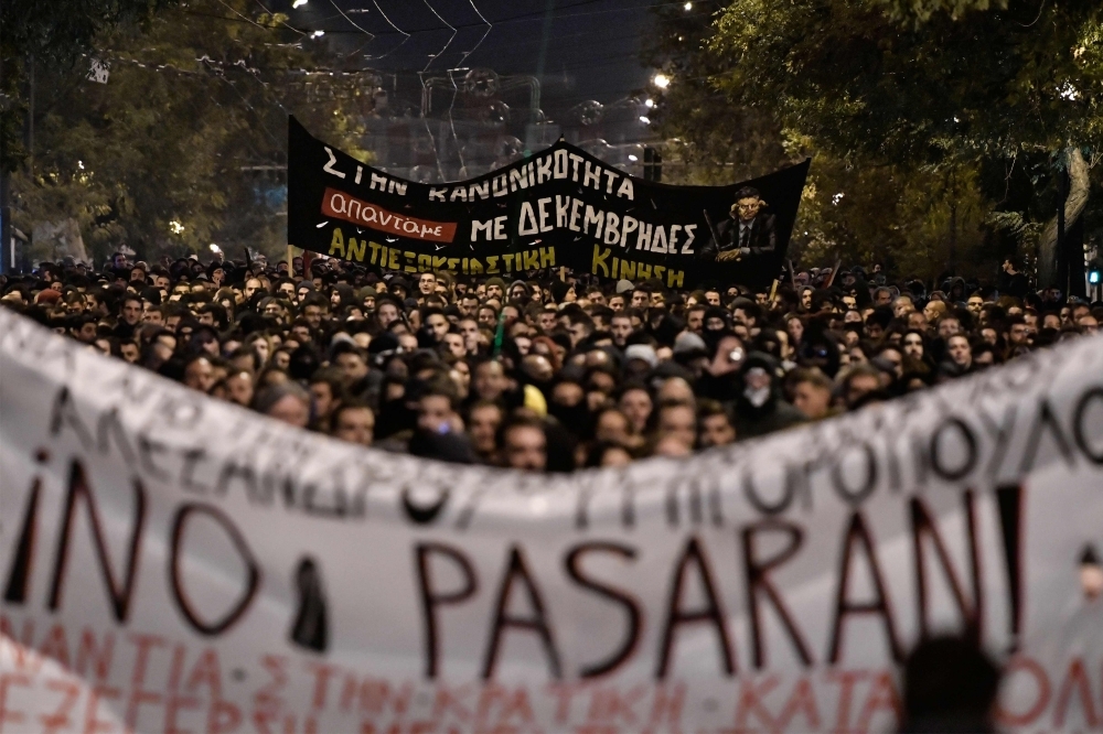  People march behind a giant banner reading 