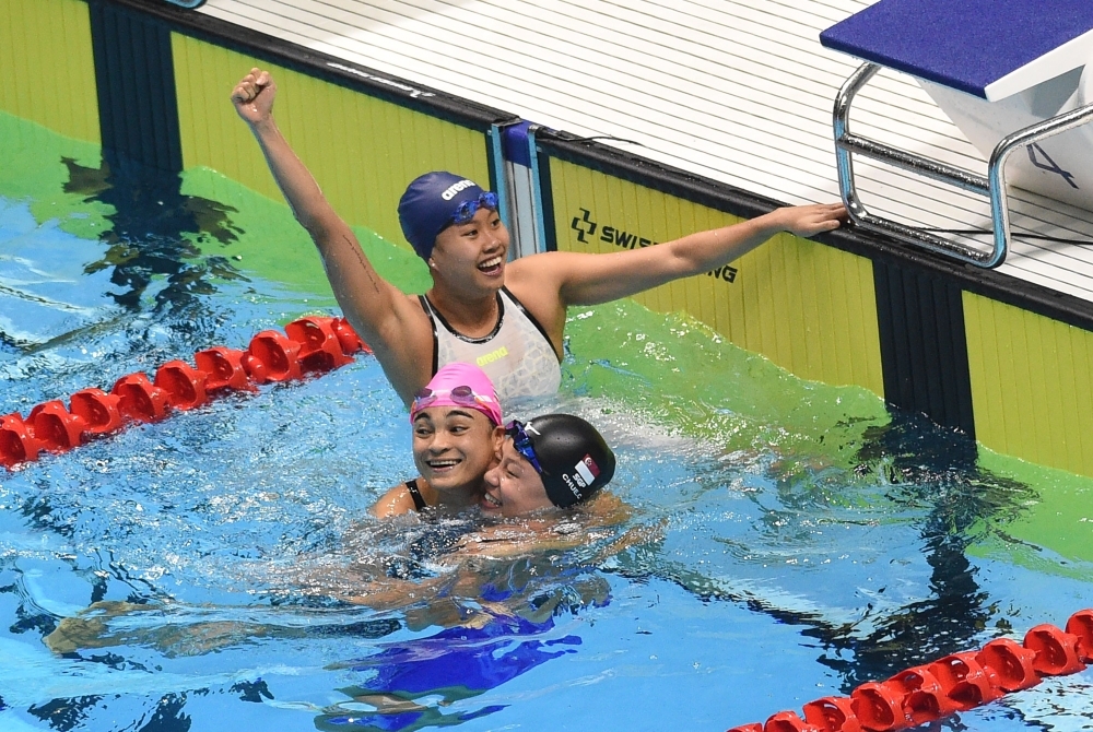 Singapore's Joseph Schooling (R) celebrates with compatriot Zhen Wen (L) after winning the men's 100m swimming butterfly during the SEA Games (Southeast Asian Games) at the Aquatic center in Clark, Capas, Tarlac province, north of Manila, on Friday. — AFP