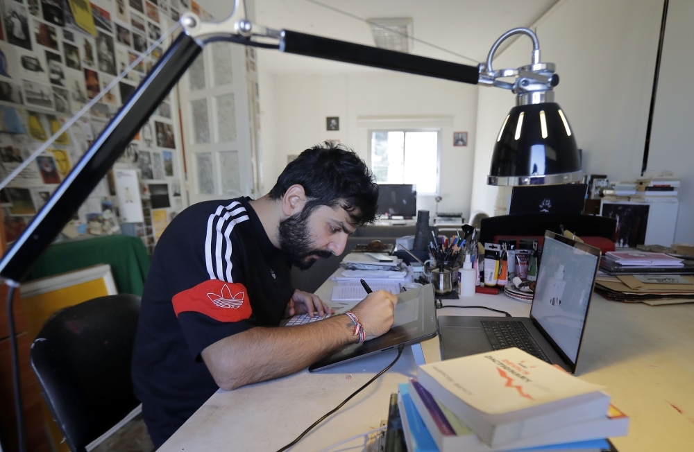  Lebanese cartoonist Bernard Haje works at his studio in Jal el-Dib, on the northern outskirts of the capital Beirut, on December 4, 2019. -AFP