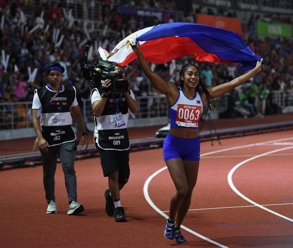 Kristina Marie Knott from the Philippines celebrates after winning in the women's 200m athletics event at the SEA Games (Southeast Asian Games) at the athletics stadium in Clark, Capas, Tarlac province north of Manila, on Saturday. — AFP