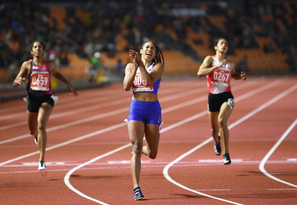 Kristina Marie Knott from the Philippines celebrates after winning in the women's 200m athletics event at the SEA Games (Southeast Asian Games) at the athletics stadium in Clark, Capas, Tarlac province north of Manila, on Saturday. — AFP