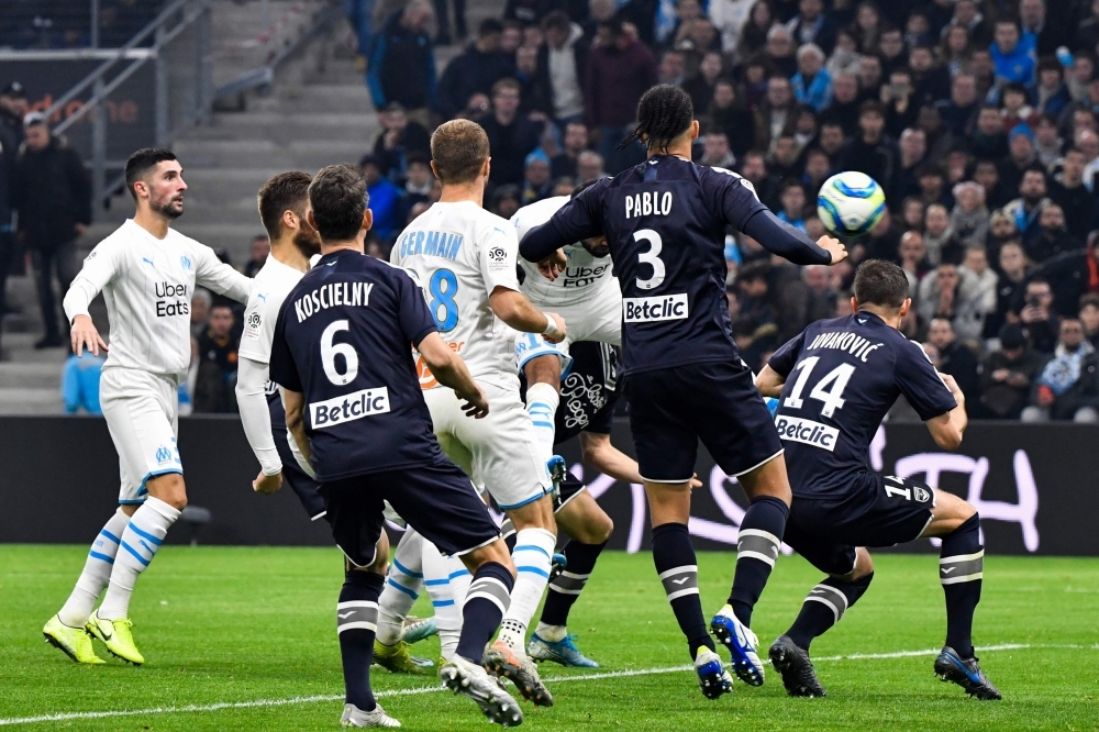 Marseille's Serbian forward Nemanja Radonjic (L) shoots and scores a goal past Bordeaux's French goalkeeper Benoit Costil (2nd-R) during the French L1 football match between Olympique de Marseille (OM) and FC Girondins de Bordeaux (FCGB) at the Velodrome Stadium in Marseille, southern France, on Sunday. — AFP