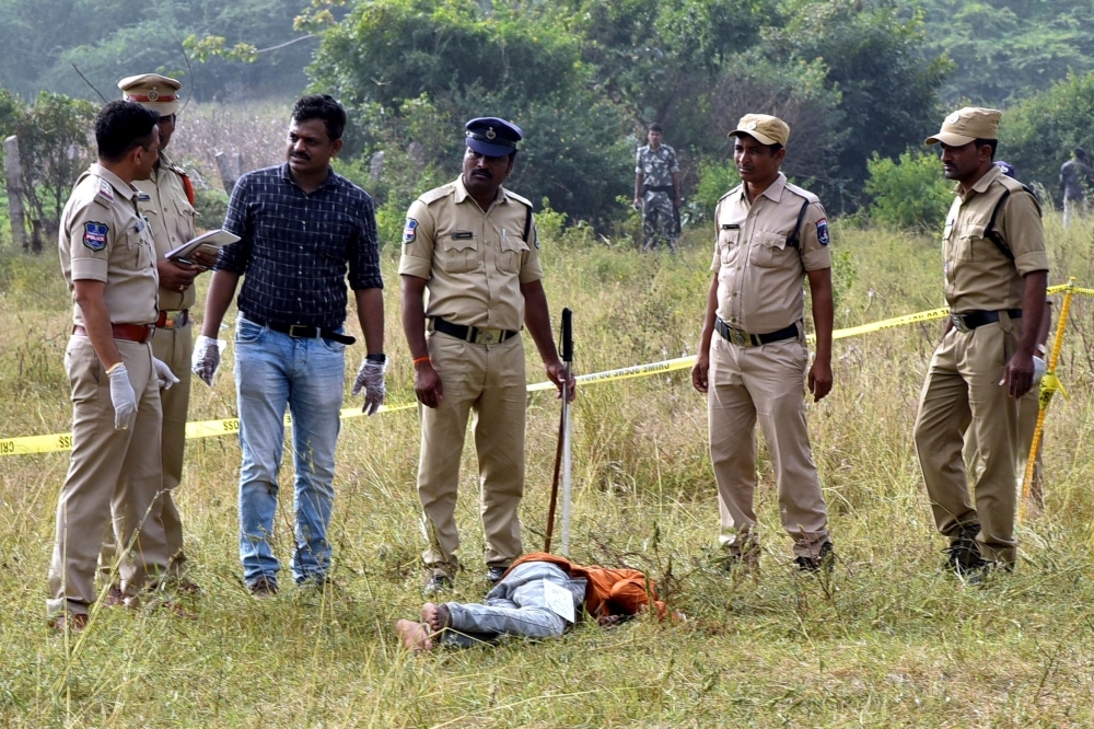 Police personnel stand next to the body of a man at the site where Police officers shot dead four detained gang rape and murder suspects in Shadnagar, some 55 km (34 miles) from Hyderabad, in this Dec. 6, 2019 file photo. — AFP