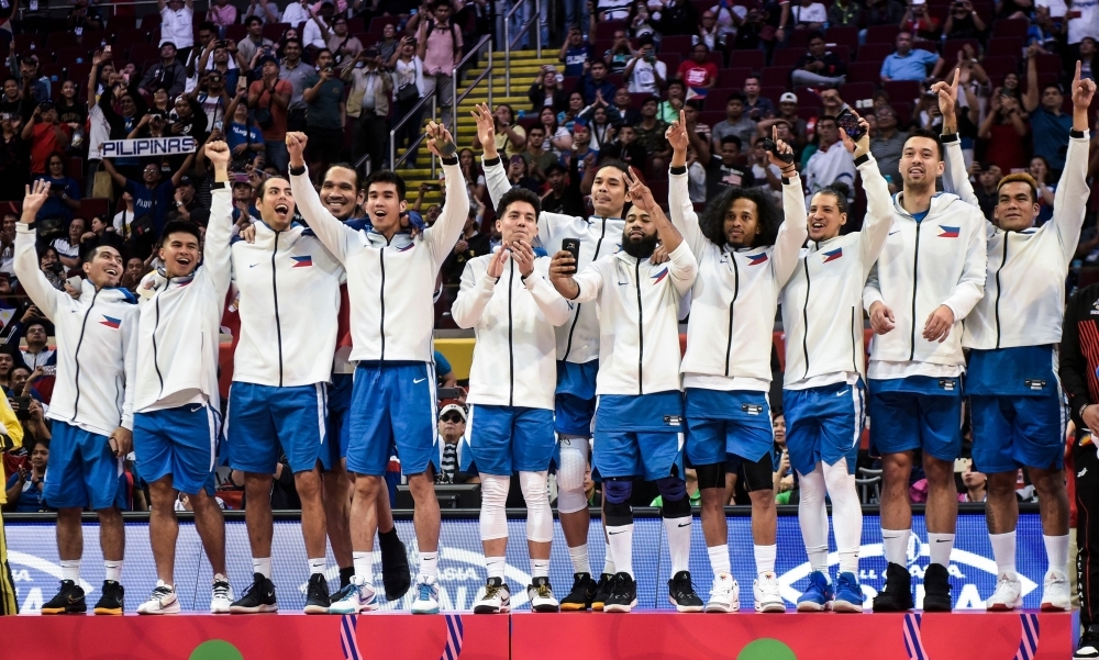 Players of the Philippines celebrate on the podium after winning gold medal in the men's final basketball event at the SEA Games (South East Asian Games) in Manila on Tuesday. — AFP