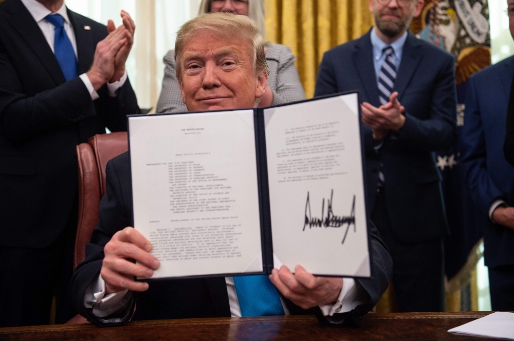 US President Donald Trump shows his signature on the Space Policy Directive-4 (SPD-4) at the White House in Washington in this Feb. 19, 2019 file photo. — AFP