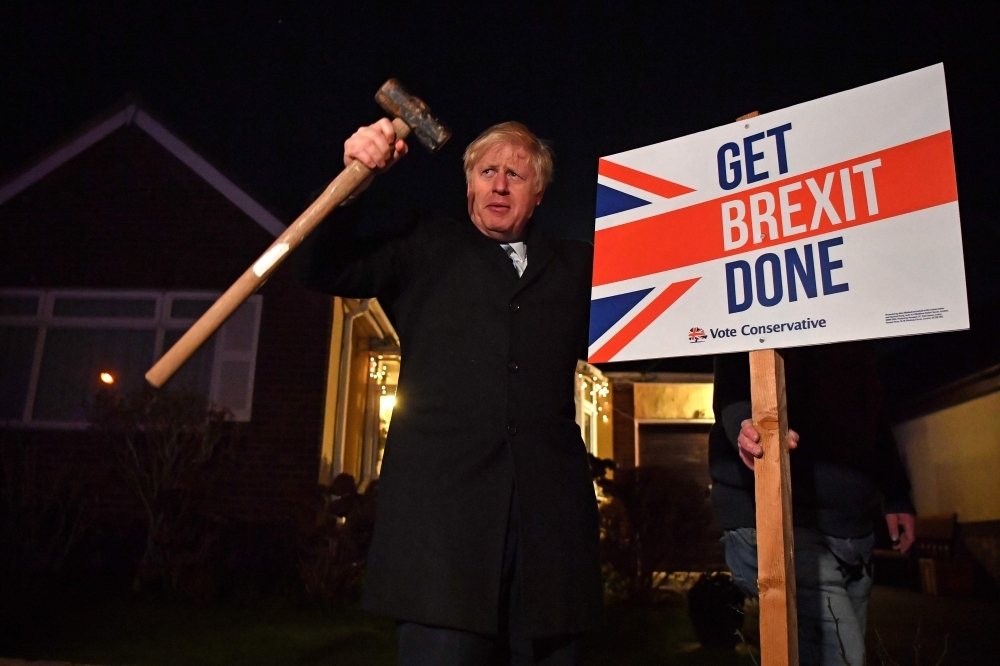 Britain's Prime Minister and Conservative party leader Boris Johnson poses after hammering a 
