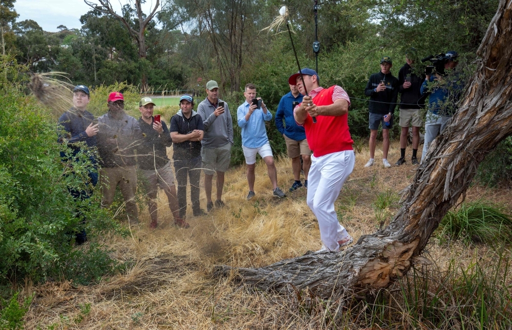 US team player Gary Woodland (R) hits from the rough during day one of the Presidents Cup golf tournament in Melbourne on Thursday. — AFP