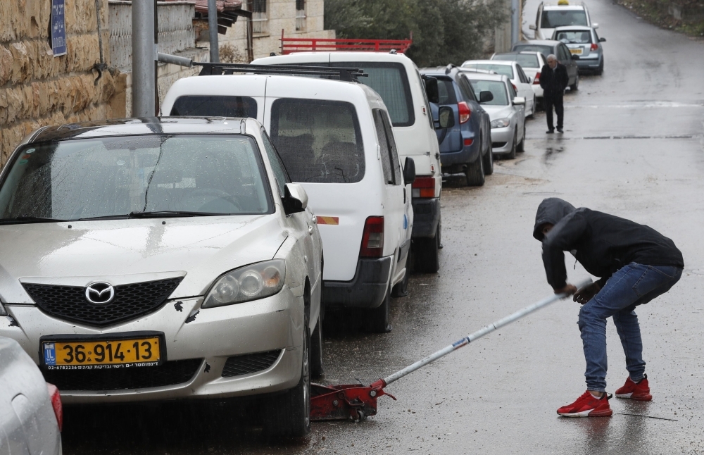 A Palestinian youth checks a car as vehicles with their tires slashed are pictured in the Palestinian neighborhood of Shuafat, neighboring the Israeli settlement of Ramat Shlomo, in Israeli annexed east Jerusalem, in this Dec. 9, 2019 file photo. — AFP