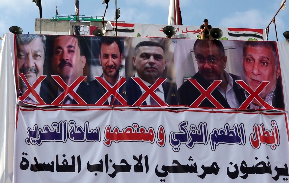 A banner hangs on a building in the Iraqi capital's Tahrir Square on Dec. 11, 2019, that shows candidates for the position of prime minister that anti-government protesters reject. — AFP