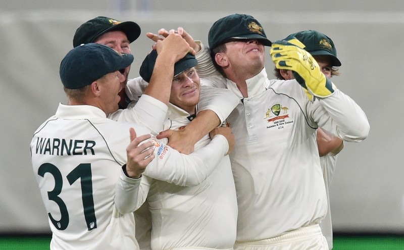 Australia's Steve Smith (3rd-L) is mobbed by his teammates after catching New Zealand captain Kane Williamson  on day two of the first Test cricket match between Australia and New Zealand at the Perth Stadium in Perth on Friday. — AFP