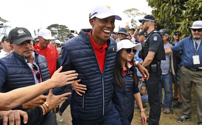 US team captain Tiger Woods (C) celebrates with girlfriend Erica Herman after the US won the Presidents Cup golf tournament on the final day in Melbourne on Sunday. — AFP