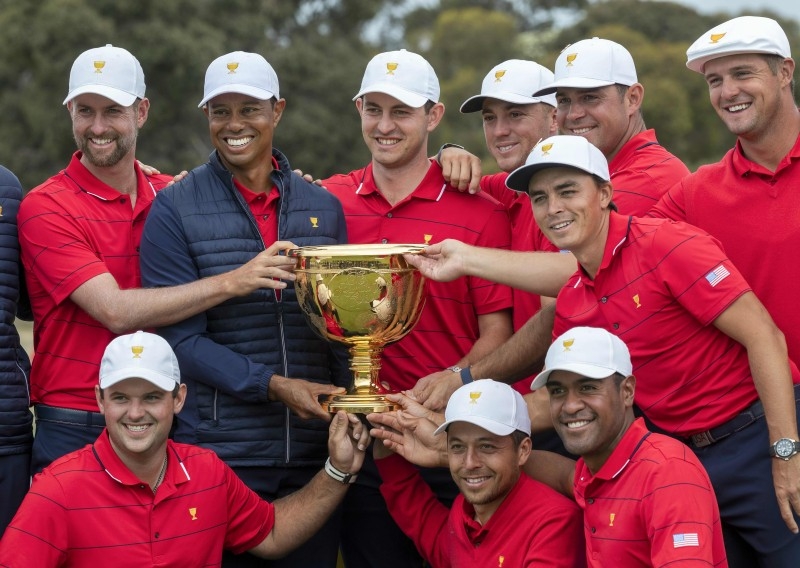 US team captain Tiger Woods (top row, 2nd L) and his teammates pose with the Presidents Cup after their win over the International Team on the final day of the Presidents Cup golf tournament in Melbourne on Sunday. — AFP