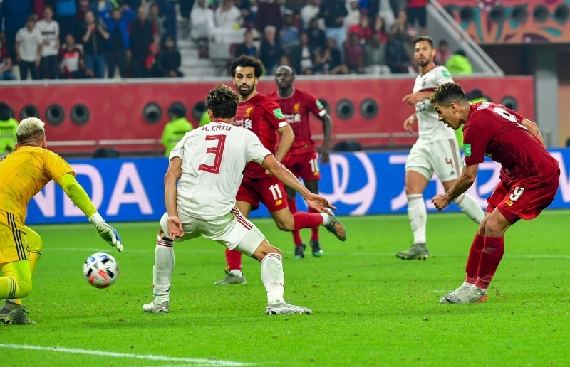 Liverpool's Brazilian midfielder Roberto Firmino (R) shoots to score during the 2019 FIFA Club World Cup Final football match against Brazil's Flamengo at the Khalifa International Stadium in the Qatari capital Doha on Saturday. — AFP