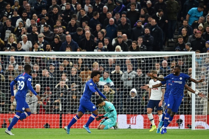 Chelsea's Brazilian midfielder Willian (C) celebrates with teammates after scoring the opening goal of the English Premier League football match against Tottenham Hotspur in London, on Sunday. — AFP
