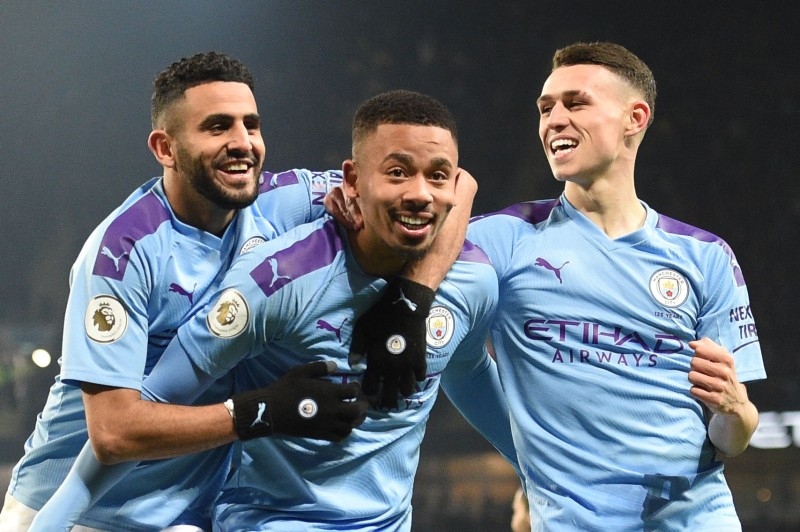 Manchester City's Brazilian striker Gabriel Jesus (C) celebrates with Manchester City's Algerian midfielder Riyad Mahrez (L) and Manchester City's English midfielder Phil Foden (R) after scoring the opening goal of the English Premier League football match against Everton at the Etihad Stadium in Manchester, north west England, on Jan. 1, 2020.  — AFP