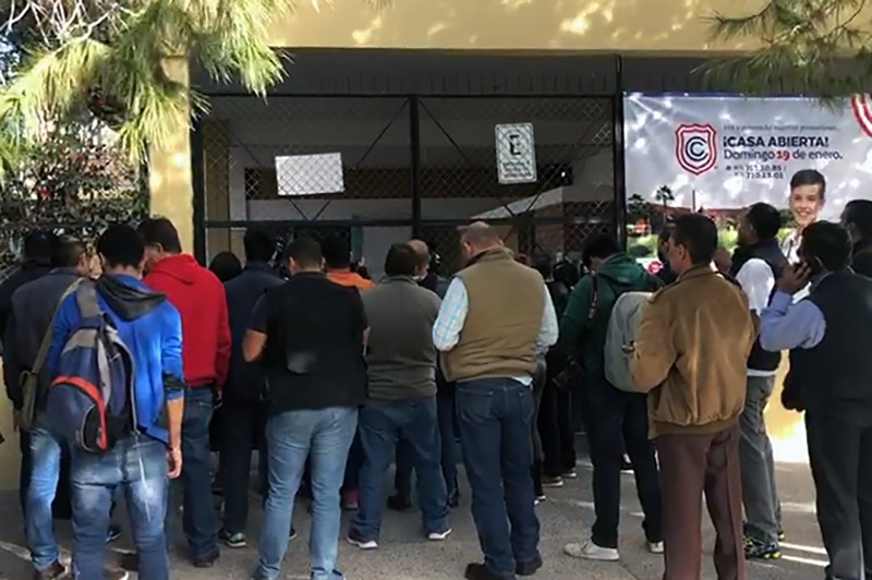 A video grab from AFP TV shows relatives of schoolchildren outside of the elementary school where a student shot and killed a teacher and wounded five other pupils, and then apparently killed himself, according to authorities, in Torreon, Coahuila state, Mexico, on Friday. — AFP