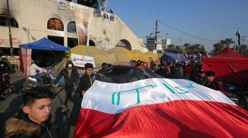 Iraqi anti-government protesters carry a large national flag during ongoing demonstrations in the capital Baghdad's Tahrir square in this file photo. — AFP