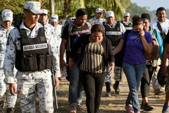 A Central American migrant family is escorted by members of the Mexican National Guard and officers of the Migration Institute after being detained crossing the Suchiate River, in Mexico. — AFP
