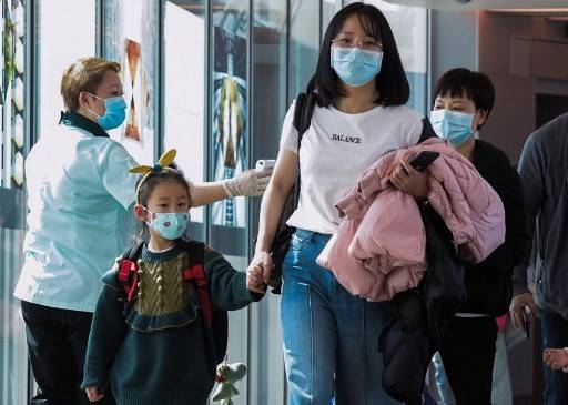 A health officer screens arriving passengers from China at Changi International airport in Singapore on Jan. 22 as authorities increased measure against coronavirus. — AFP