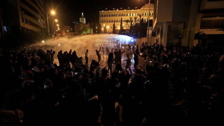 Demonstrators are sprayed by a water cannon during a protest against the newly formed government outside the government headquarters in downtown Beirut. — Courtesy photo