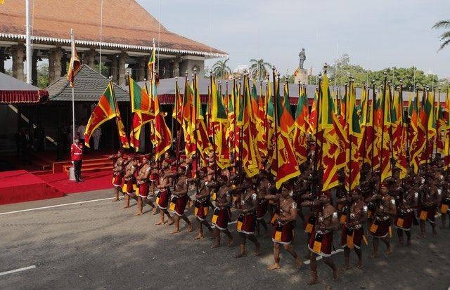 Sri Lankan soldiers in traditional attire march carrying national flags in this file picture. — Courtesy photo