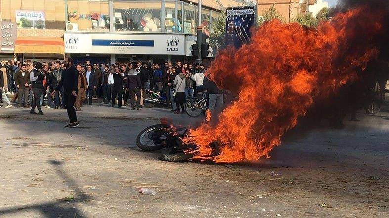 Iranian protesters gather around a burning motorcycle during a demonstration against an increase in gasoline prices in the central city of Isfahan, in last November. — AFP