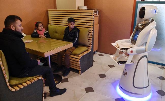 Afghanistan's first-ever robot waitress glides up to a table of curious diners in central Kabul and presents them with a plate of French fries. — AFP