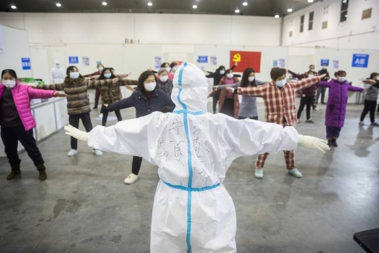 Medical staff in Wuhan, the centre of China's coronavirus outbreak, lead patients in group exercises at a hospital. — AFP