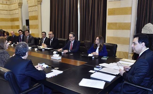 In this photo released by the Lebanese government, Lebanese Prime Minister Hassan Diab, right, meets with delegation from the International Monetary Fund at the Government House in Beirut, Lebanon, on Thursday. 