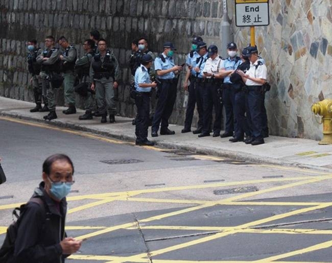 Dozens of Hong Kong police officers, seen here masked during the protests, have been placed in quarantine after attending a banquet with a colleague who later tested positive for the new coronavirus, officials said Friday.
