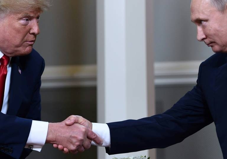 US President Donald Trump and Russian President Vladimir Putin shake hands ahead of a meeting in Helsinki in July 2018. — AFP