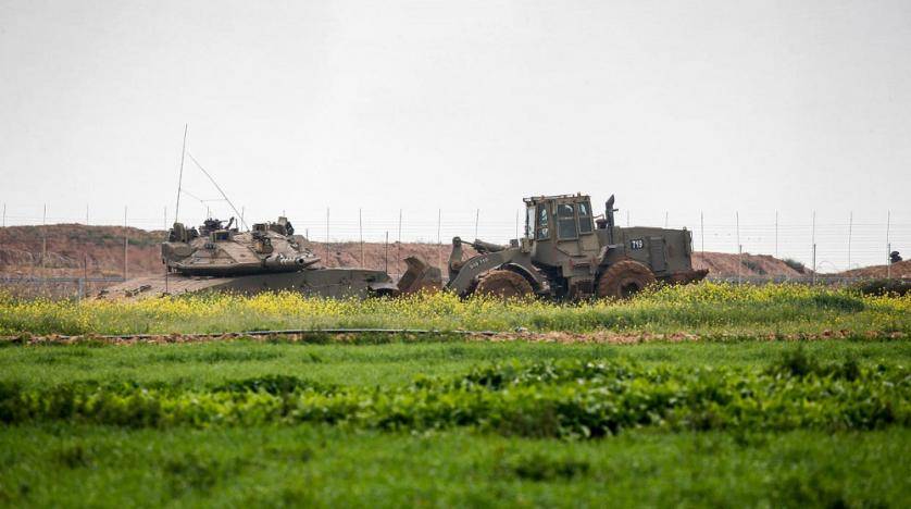 An Israeli tank and a bulldozer are seen along the border fence between Israel and the Gaza Strip where the army says troops shot dead a Palestinian suspected of placing a bomb near the barrier. — Courtesy photo