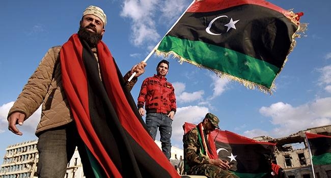 Libyans wave their national flag in Benghazi as they take part in a celebration marking the Libyan revolution. — Courtesy photo