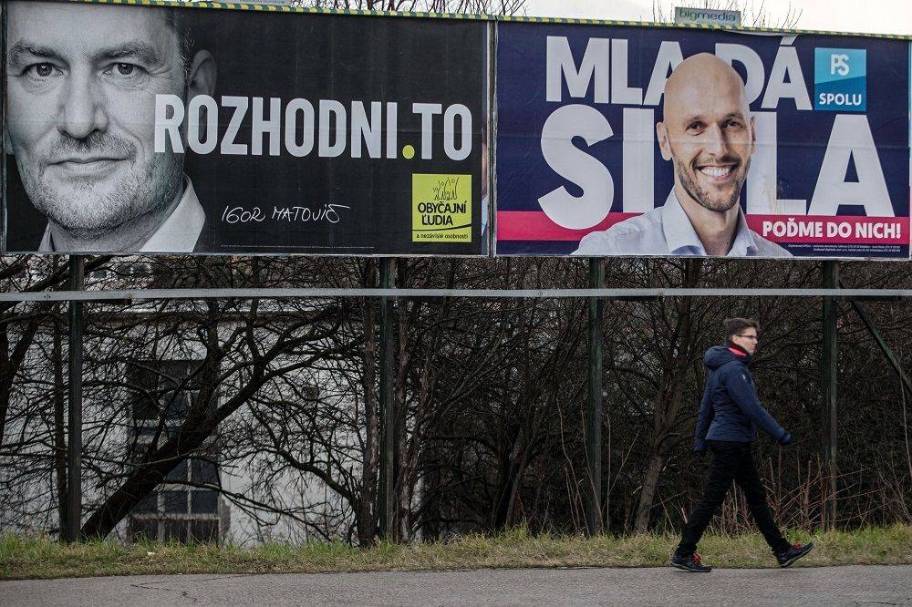 A woman walks past election posters of leader of the Ordinary People and Independent Personalities party, Igor Matovic (left), and leader of PS/Together party, Michal Truban, in Bratislava, Slovakia. – Courtesy photo