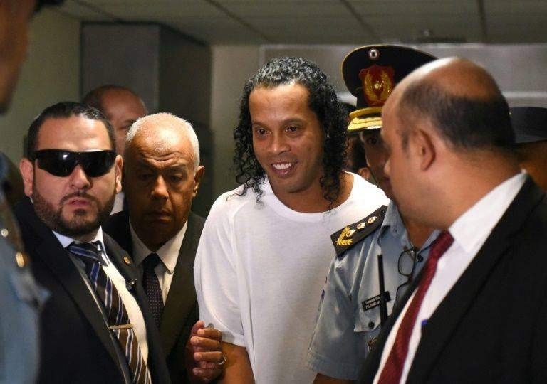 Retired Brazilian football star Ronaldinho, center, has been charged in Paraguay with using a public document with false content. — AFP