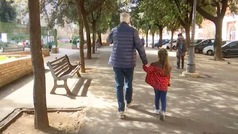 A young girl walks with her elderly grandparent along a tree lined avenue in Rome, Italy. — Courtesy photo