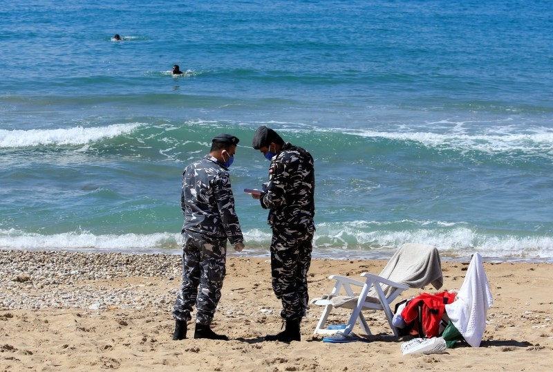 Lebanese officials issue fines at the beach in Sidon amid the nationwide lockdown.