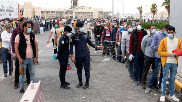 Expatriates wait for mandatory coronavirus testing in a makeshift testing center in Mishref, Kuwait, in this file photo.
