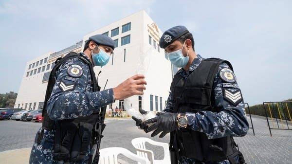 Special forces wearing protective masks are seen at the entrance to a Kuwaiti hotel in Fahaheel where people evacuated from Iran are being held in quarantine. -- Courtesy photo