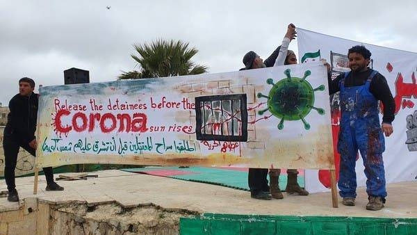 Aziz Asmar with a coronavirus mural in Idlib.

