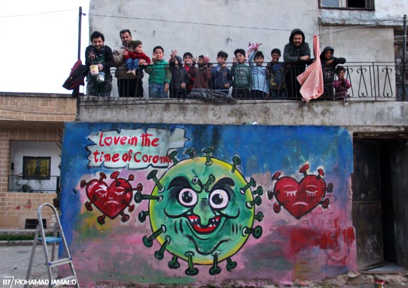 Aziz Asmar with a coronavirus mural in Idlib.

