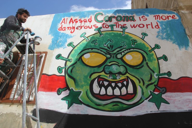 Aziz Asmar with a coronavirus mural in Idlib.

