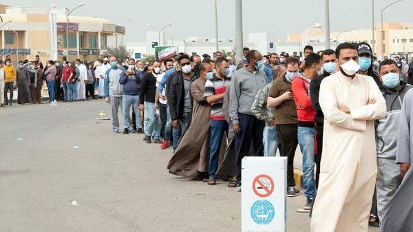 Expatriates wait in line to be tested at a makeshift center, following the outbreak of coronavirus, in Mishref, Kuwait, in this March 14, 2020 picture. — Courtesy photo
